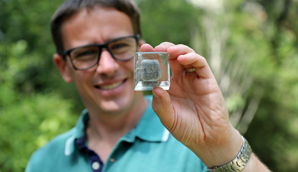 Ecology professor Scott Carver holds a wombat poo that he preserved in acrylic. Wombat poo is square, and no one knew why until Carver and a team of scientists investigated. Their efforts won a 2019 Ig Nobel Prize, which honors achievements that “first make people laugh and then make them think.” (Photo: Allyson Mann)