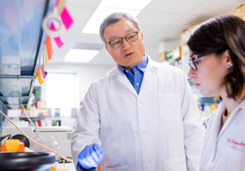 Biao He in lab with student