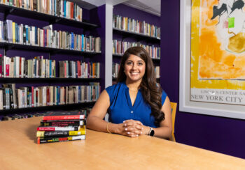 An image of Rumya Putcha sitting at a table in a library. Rumya Putcha is an associate professor of music and women’s studies in the Franklin College of Arts and Sciences.