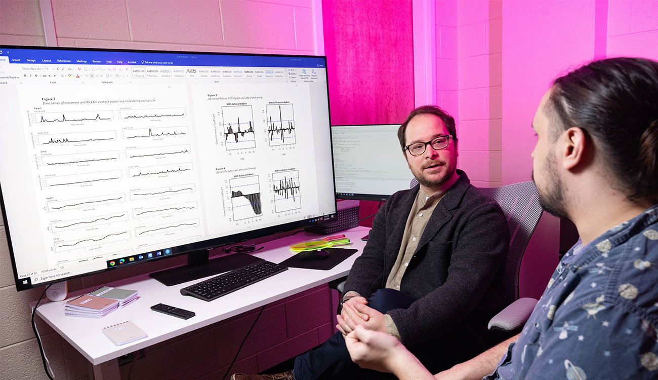 Drew Abney works with a research partner with data displayed on a computer screen.