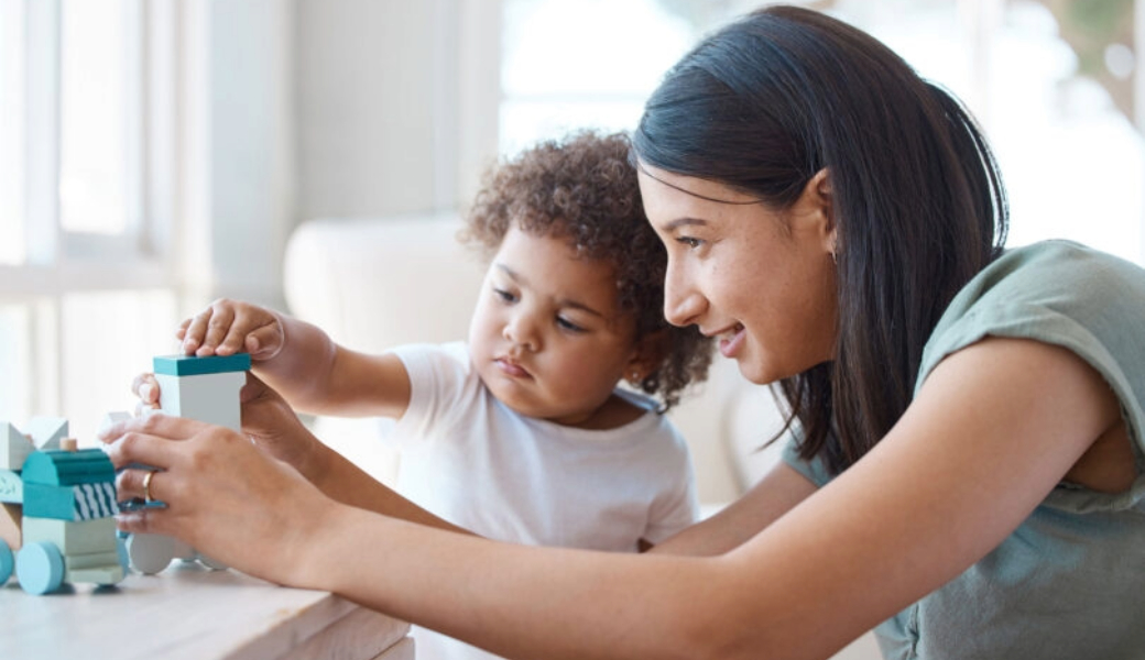 Image of a child and mother playing with building blocks and toys.