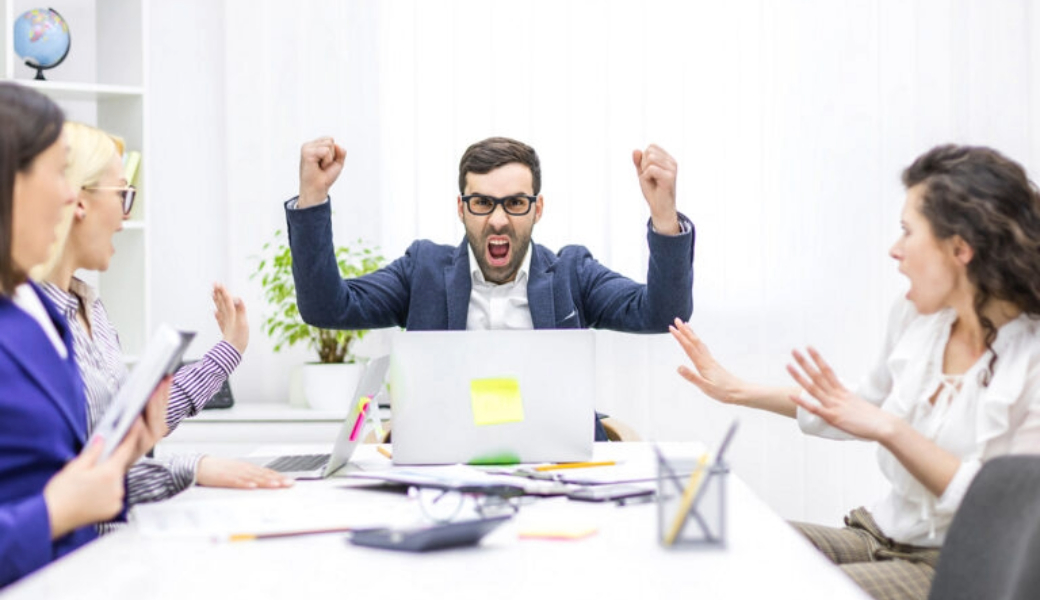 Image of an angry boss in a meeting with his team.