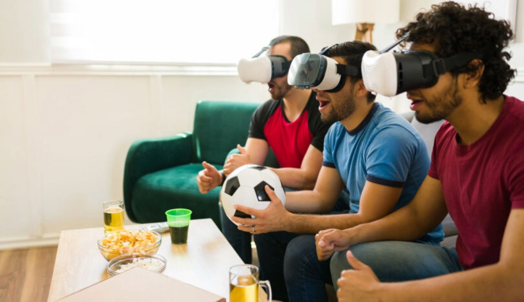 An image of three men watching a sports game with VR headsets.