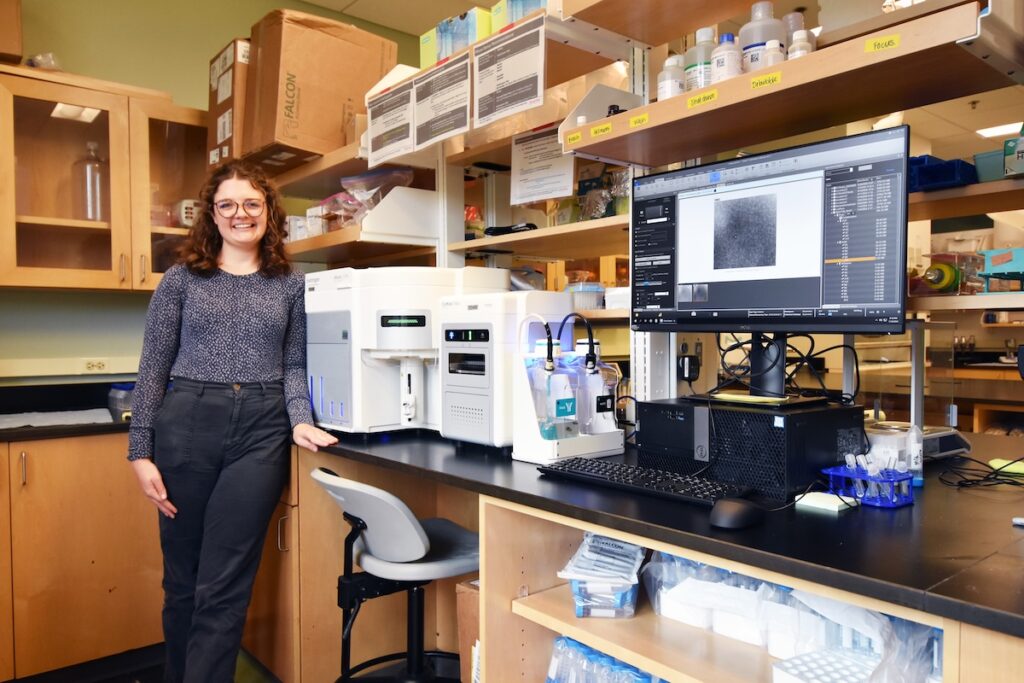 Claire Zwiers Cook, a doctoral student in Natalie Cohen’s lab, stands next to the new Attune CytPix Flow Cytometer. Photo by Jackson K. Schroeder.