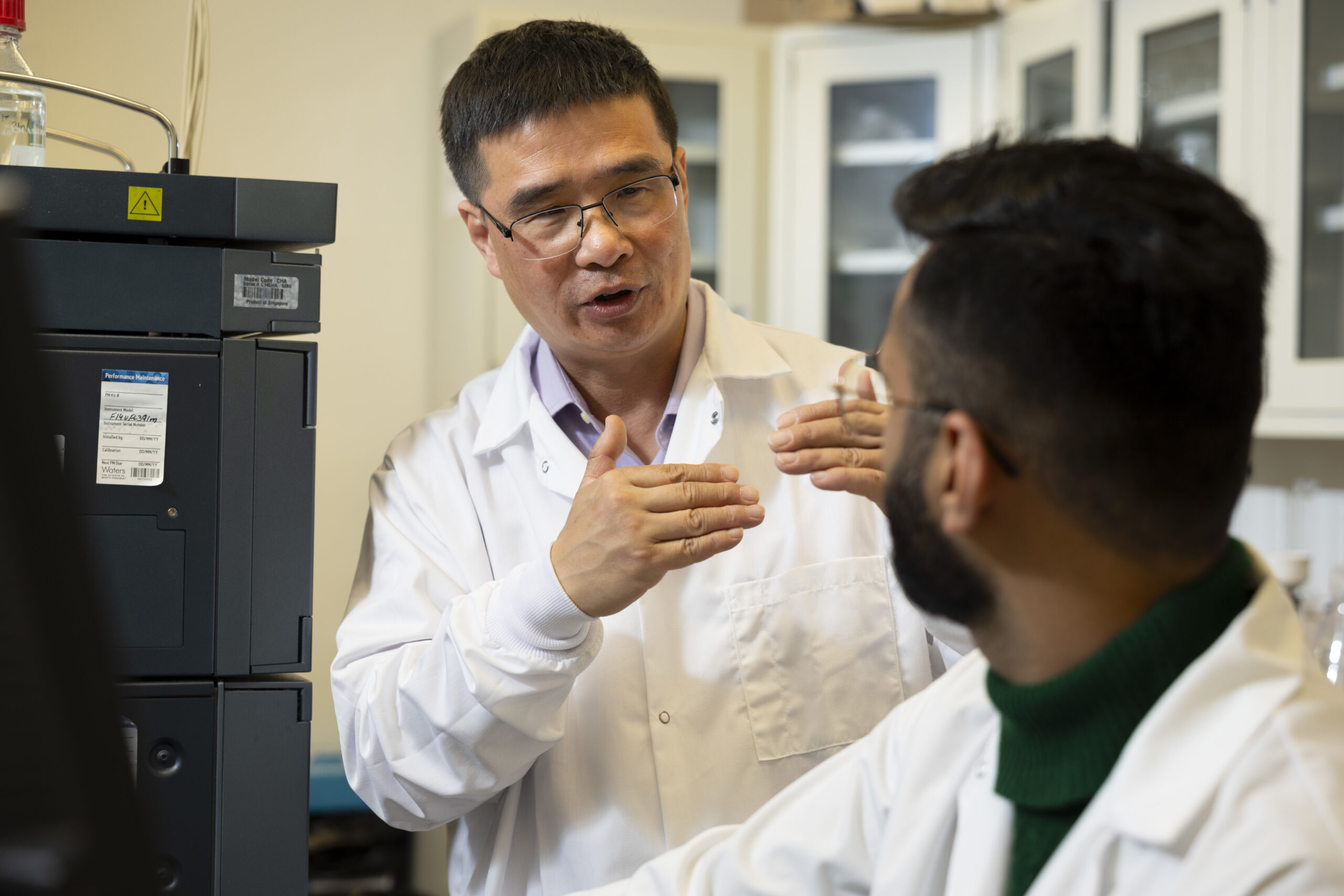 Huang (left) and graduate student Umar Munir collaborate in a Griffin Campus laboratory.