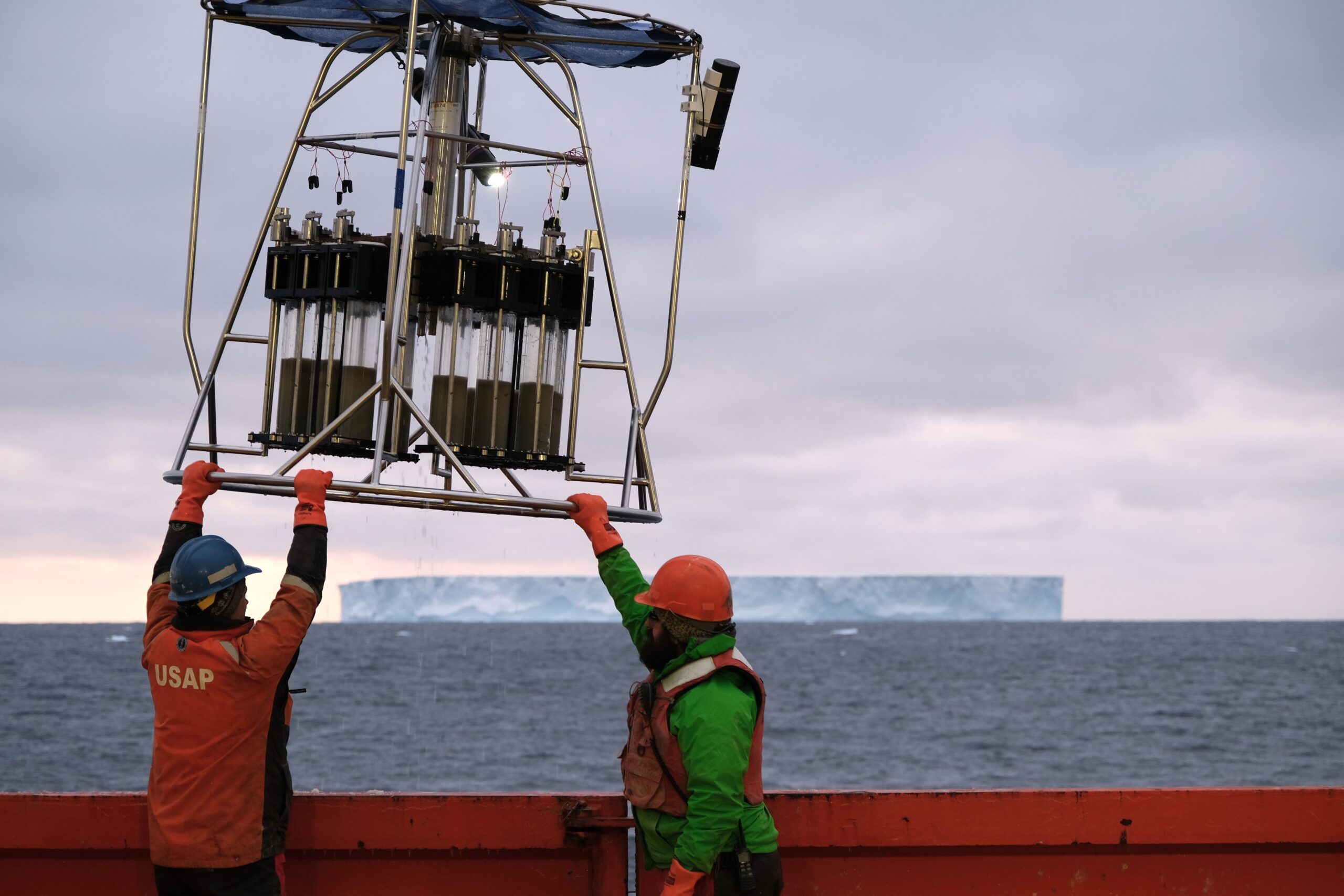 Researchers lift a device out of the water