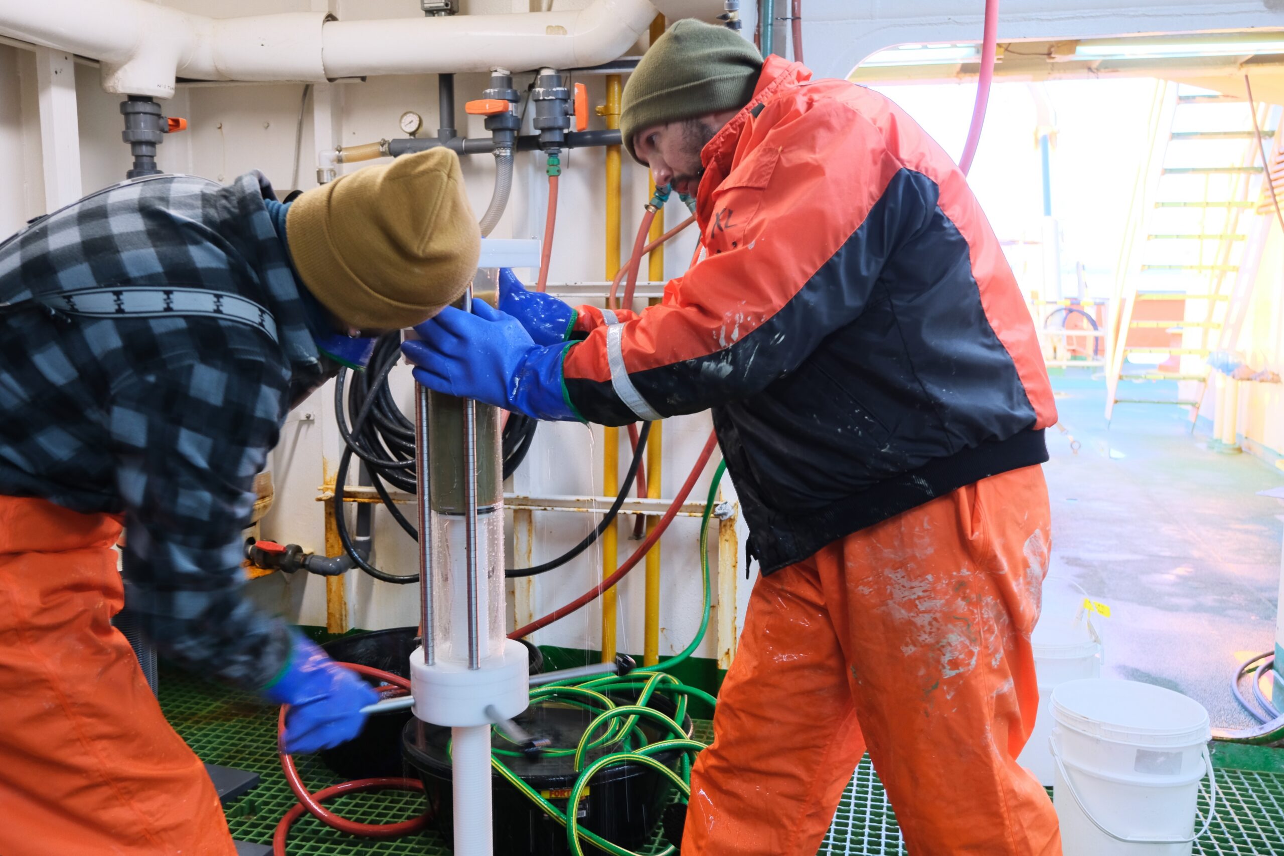 Researchers examine a sample of mud brought out of the ocean floor