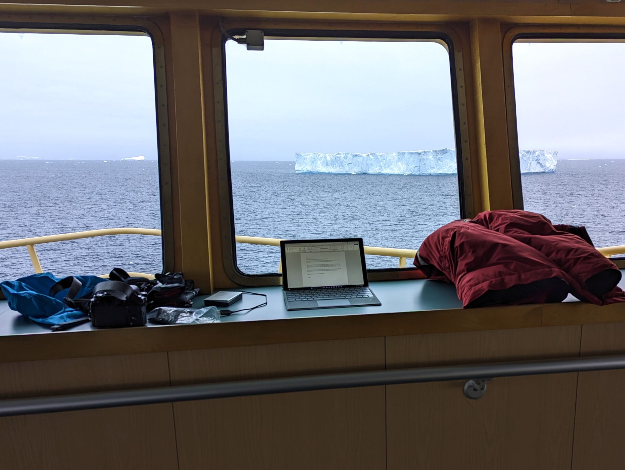 An iceberg seen through the window of the bridge of the ship