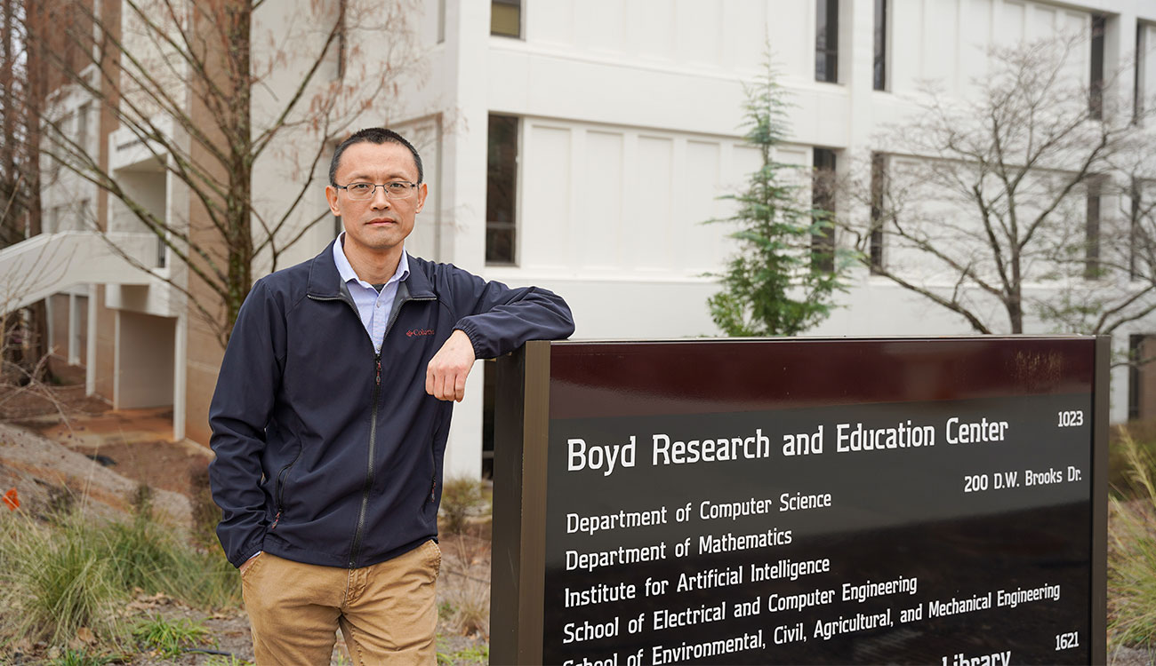 Jidong Yang stands in front of the entrance of Boyd Research and Education Center