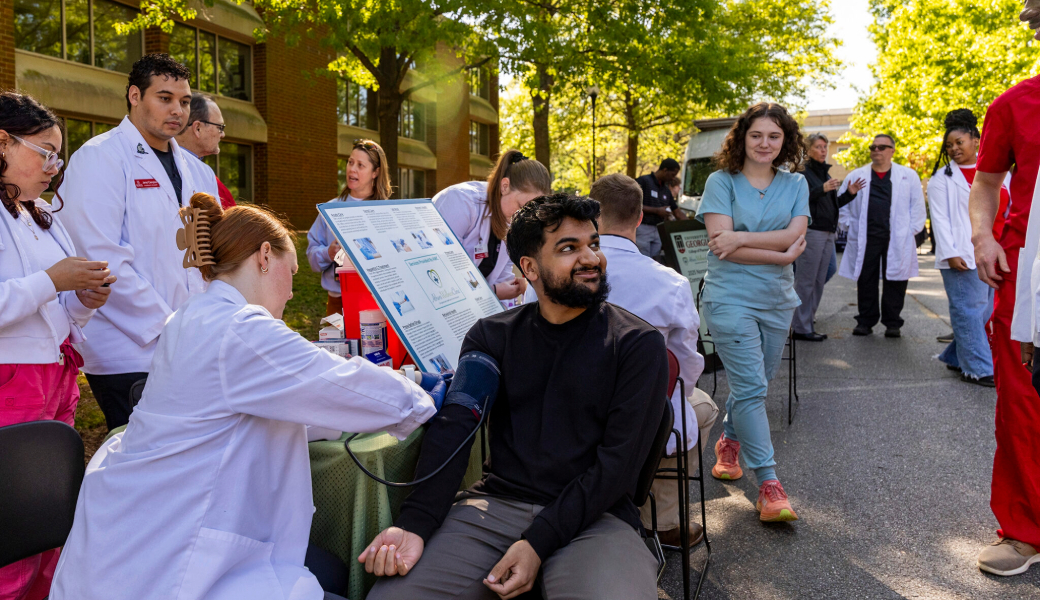 Pharmacy student Hannah Matthewson takes the blood pressure of Medical Partnership student Muhammed Mumen during the Community Health Fair at the Health Sciences Campus.