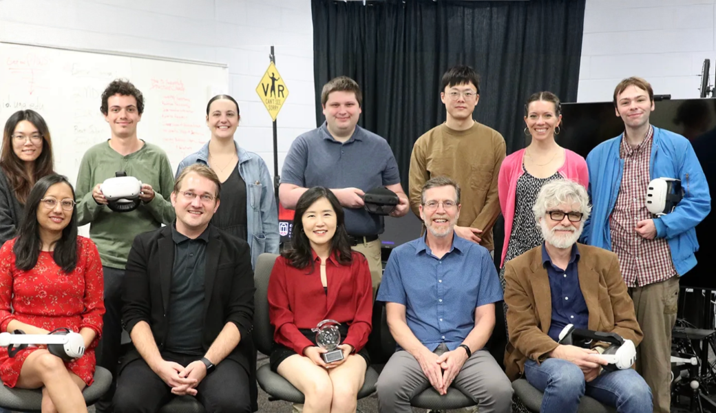Project leads and researchers from the Center for Advanced Computer-Human Ecosystems (CACHE) gather to celebrate receiving the Georgia Clinical and Translational Science Alliance Presidents' Award of Distinction. Grace Ahn, CACHE founding director (center, front row), holds the award on her lap.