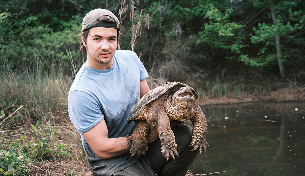 Michael Skibsted in Atlanta holding a spry common snapping turtle (Chelydra serpentina). (Photo by Ken Wang)