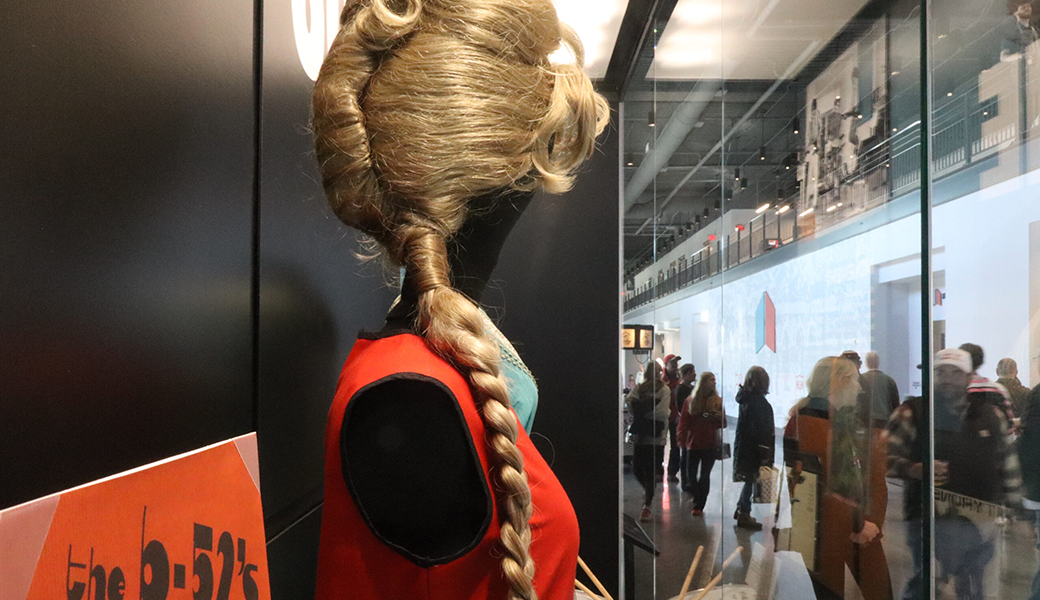 A blonde beehive wig complements a Mondrian-inspired dress, both worn by B-52s’ and Athens’ own Cindy Wilson. The display case, “Making a Scene,” currently houses iconic B-52s memorabilia. (Photo by Caroline Newbern)