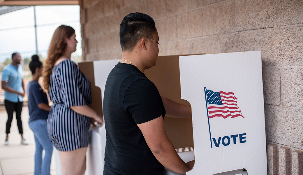 Person using a voting booth to cast a vote.