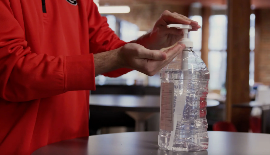 Image of a person pumping hand sanitizer into their hands.