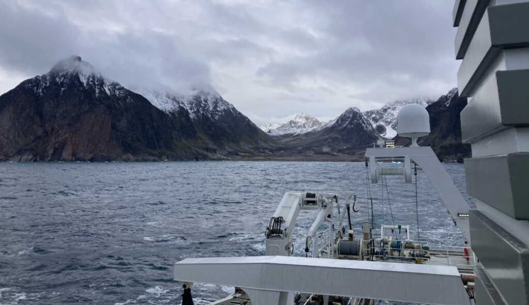 Image of mountains and a sea taken from a boat.