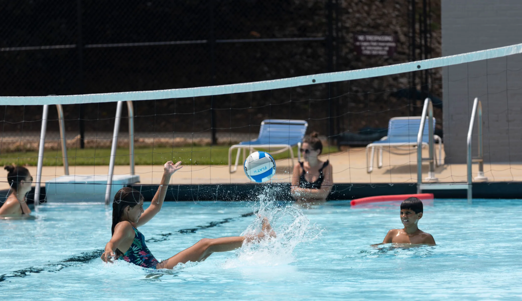 Image of kids playing with a ball and net in the pool.