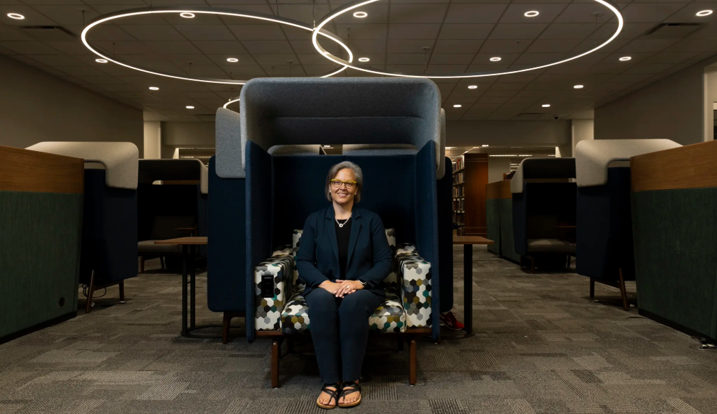 An image of Emily Core sitting at a chair/desk setup at Science Library at UGA.