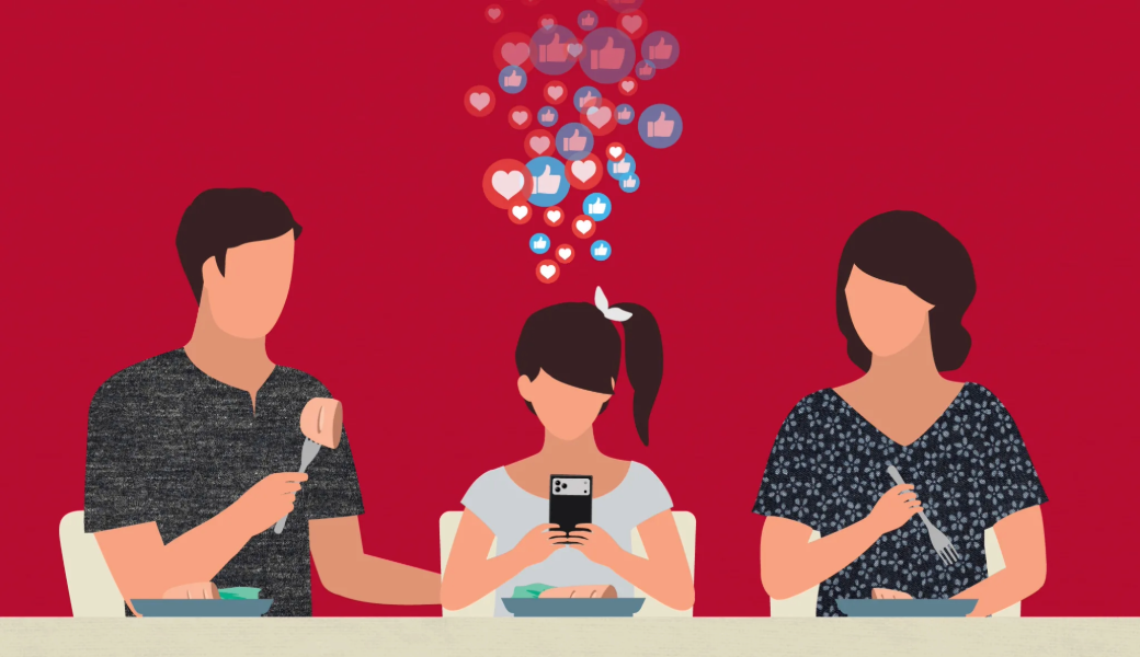 Image of a teen girl on her phone while eating a meal with her parents.