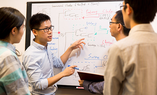 researchers working at white board