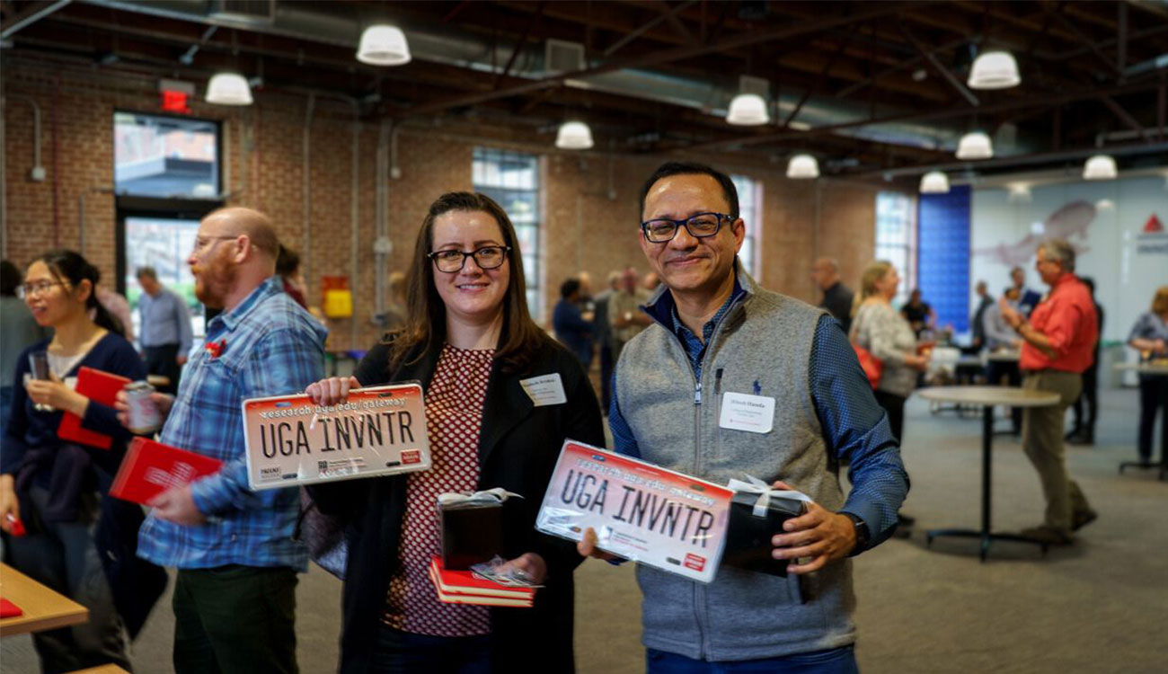 Faculty members Elizabeth Brisbois (left) and Hitesh Handa (right) pose after picking up their commemorative swag at UGA’s Innovation Celebration, held Feb. 5 in the Delta Innovation Hub. (Photo by Brandon Ward)